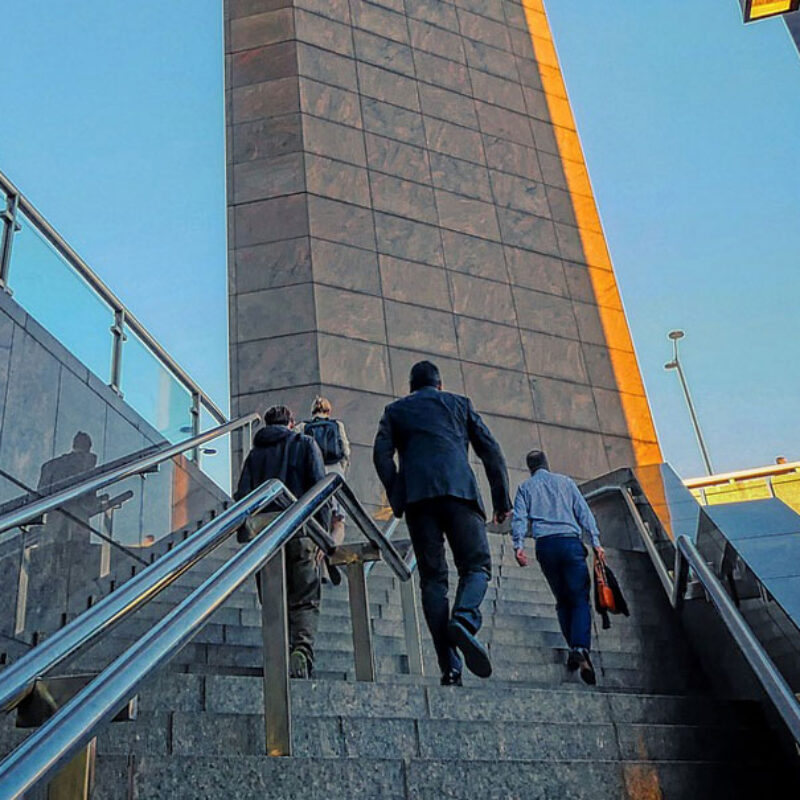 Executives climbing stairs outside an impressive office building